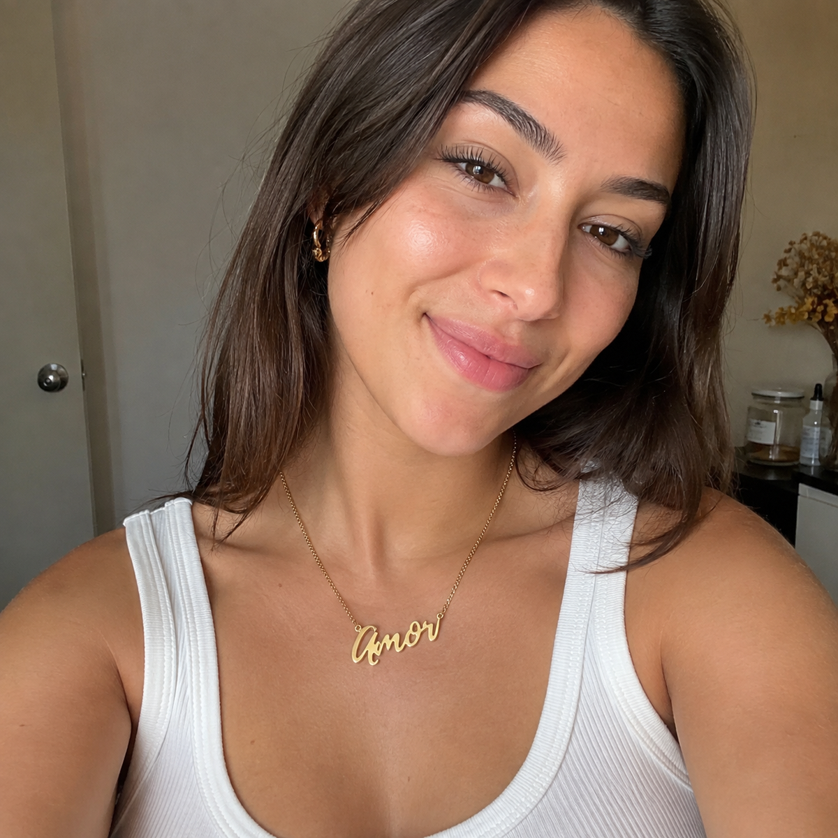 "Amor" Necklace styled photo - gold script cutout pendant on display Anthology Jewelry