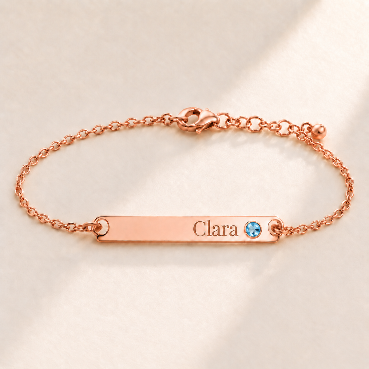 Birthstone Bar Bracelet hero photo - rose gold december blue topaz with Clara engraving in Playfair Display Anthology Jewelry