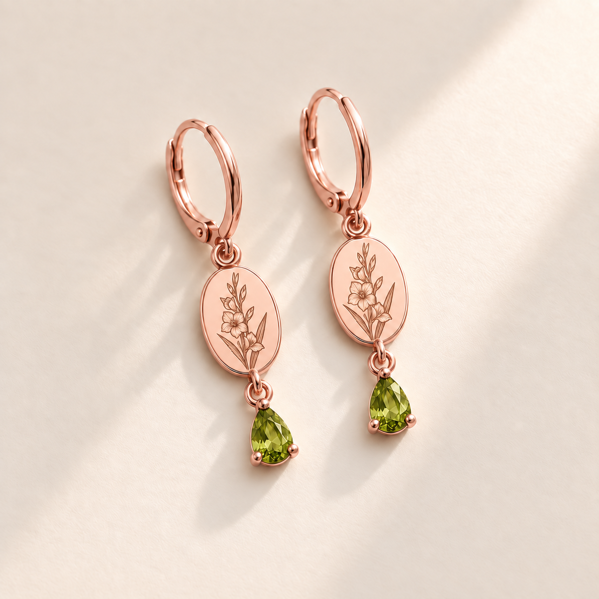 Custom Birth Flower & Birthstone Drop Earrings august rose gold hero photo - engraved gladiolus stem with multiple flowers and buds and long pointed leaves with yellow-green peridot pear stones Anthology Jewelry