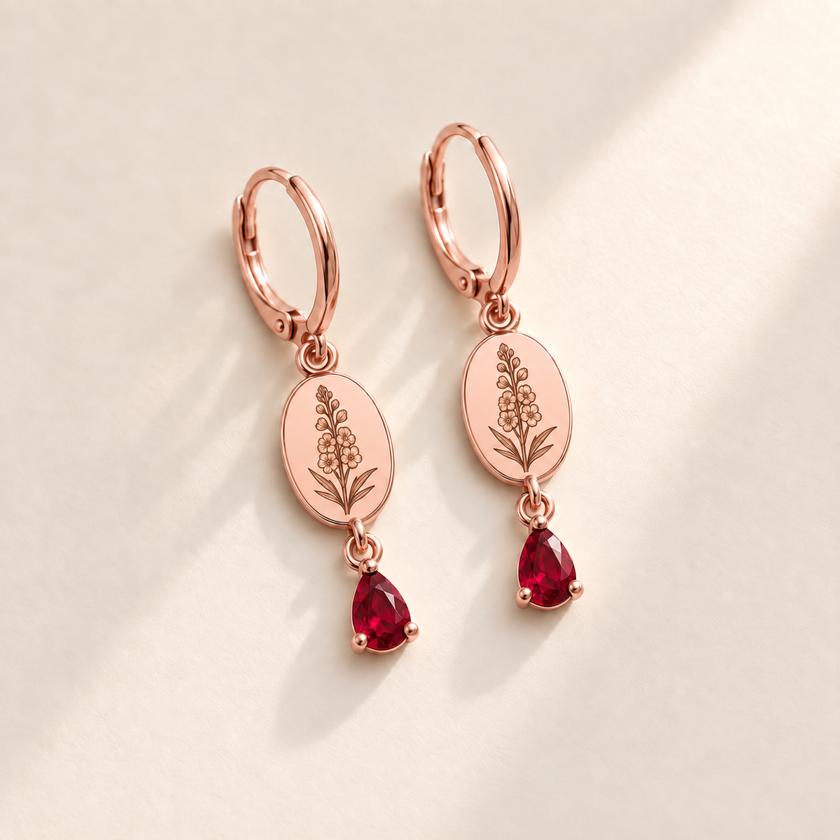 Custom Birth Flower & Birthstone Drop Earrings july rose gold hero photo - engraved tall larkspur stalk with clustered small flowers, buds and narrow leaves with ruby red pear stones Anthology Jewelry