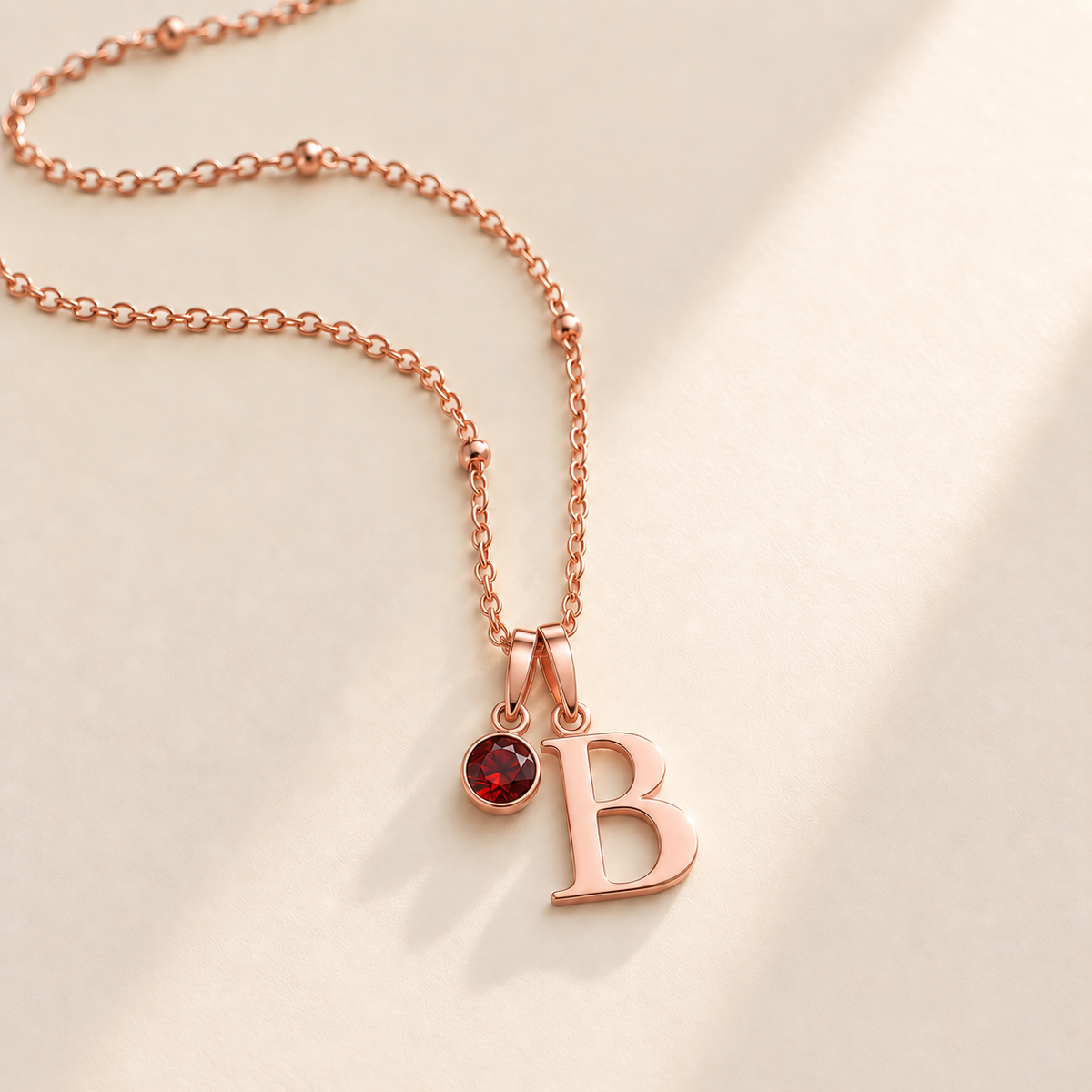 Custom Birthstone Initial Necklace hero rose gold photo - two separate bails with serif initial B and round birthstone Anthology Jewelry
