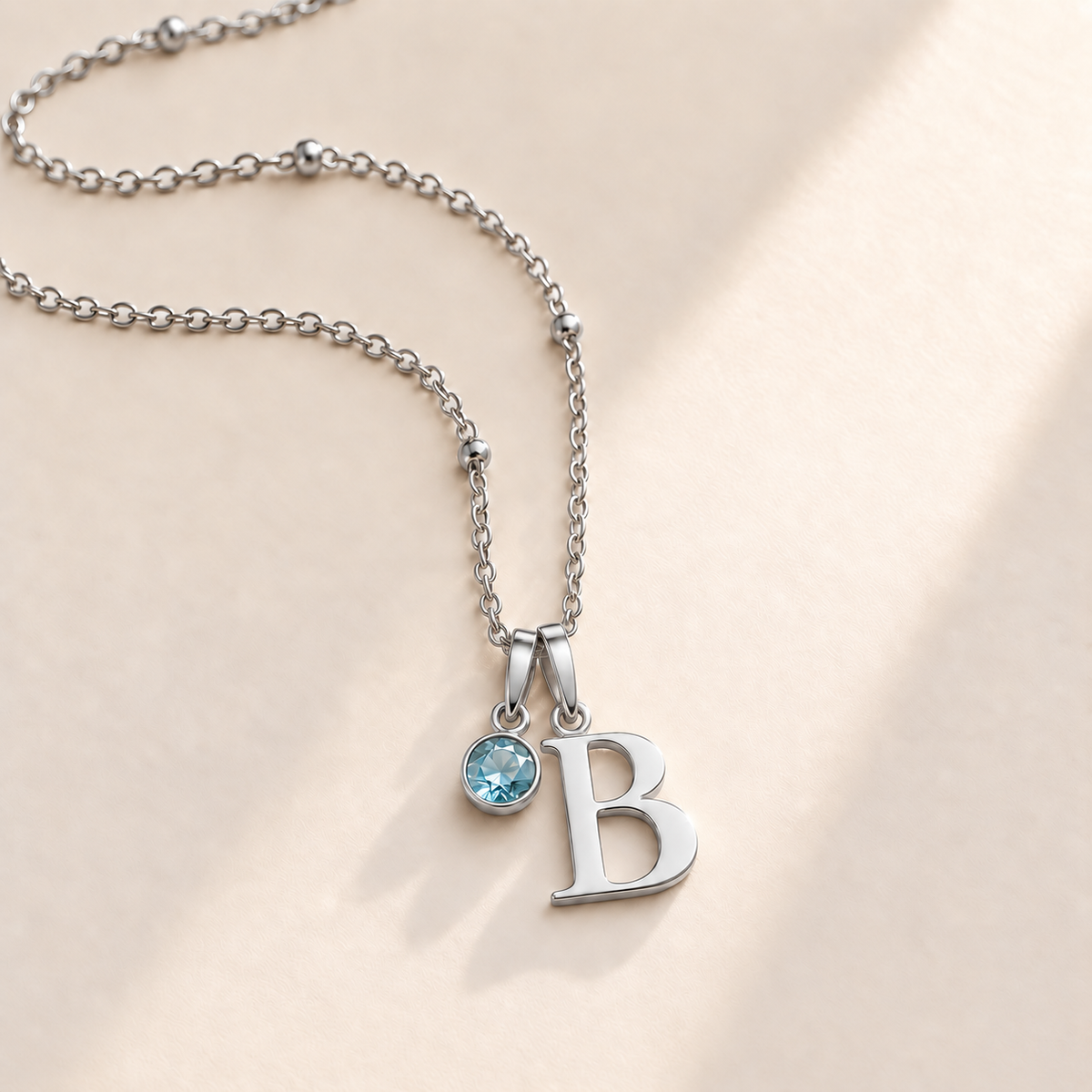Custom Birthstone Initial Necklace silver March birthstone photo - serif initial B with round pale blue stone Anthology Jewelry
