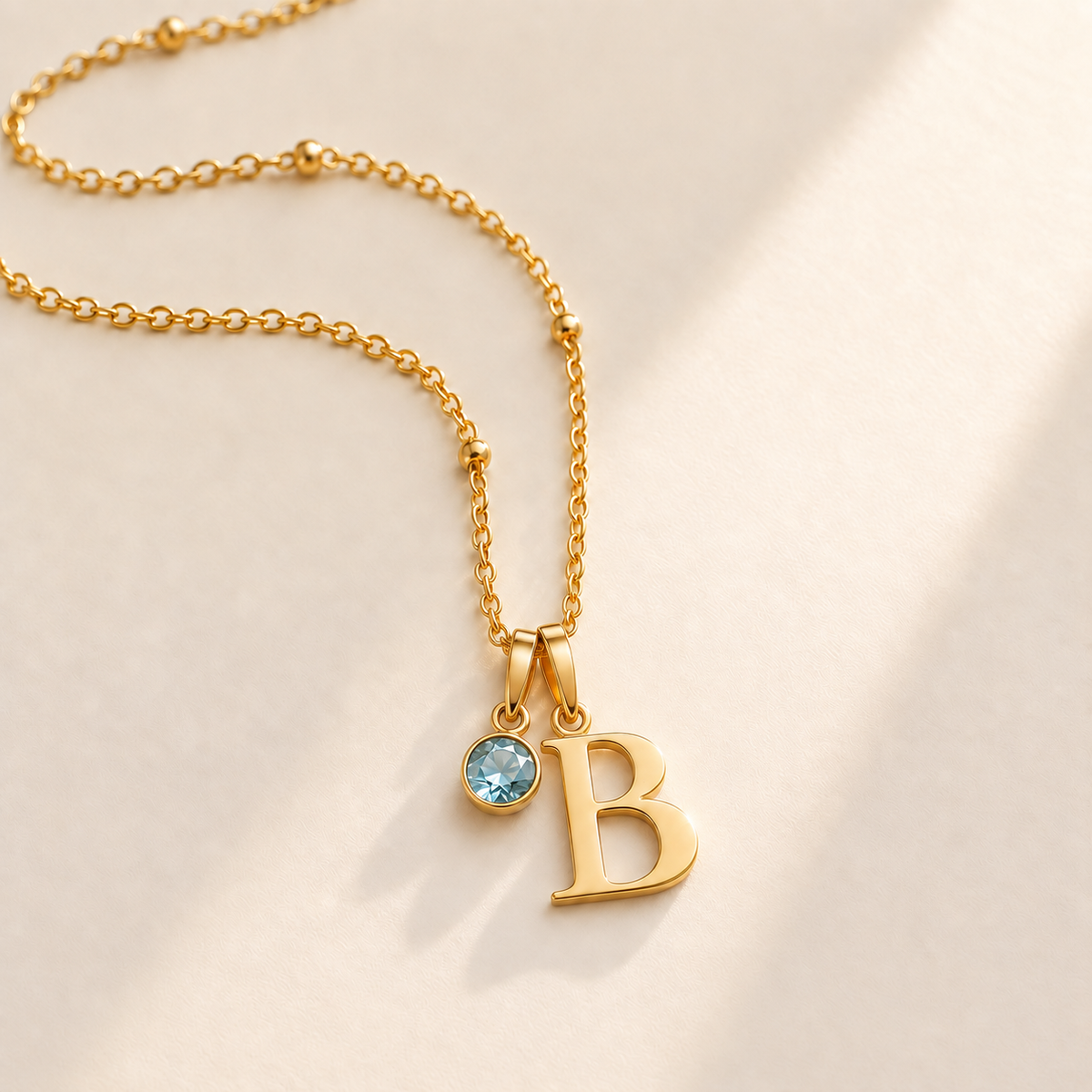 Custom Birthstone Initial Necklace stone march photo - two separate bails with serif initial B and round birthstone Anthology Jewelry