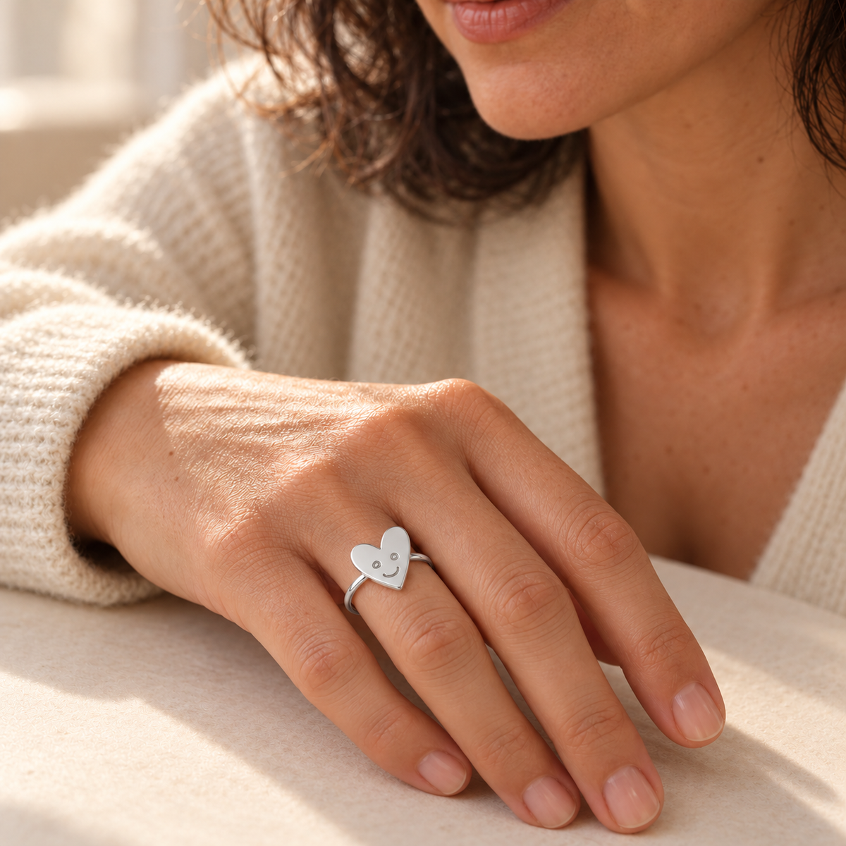 Custom Drawing Ring lifestyle photo - asymmetric child-drawn smiling heart in silver on a separate slim band worn on an adult woman's hand Anthology Jewelry