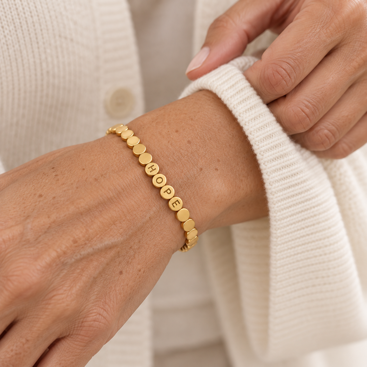 Custom Engraved Dot Bracelet lifestyle photo - gold linked dot bracelet with engraved letters worn on the wrist Anthology Jewelry