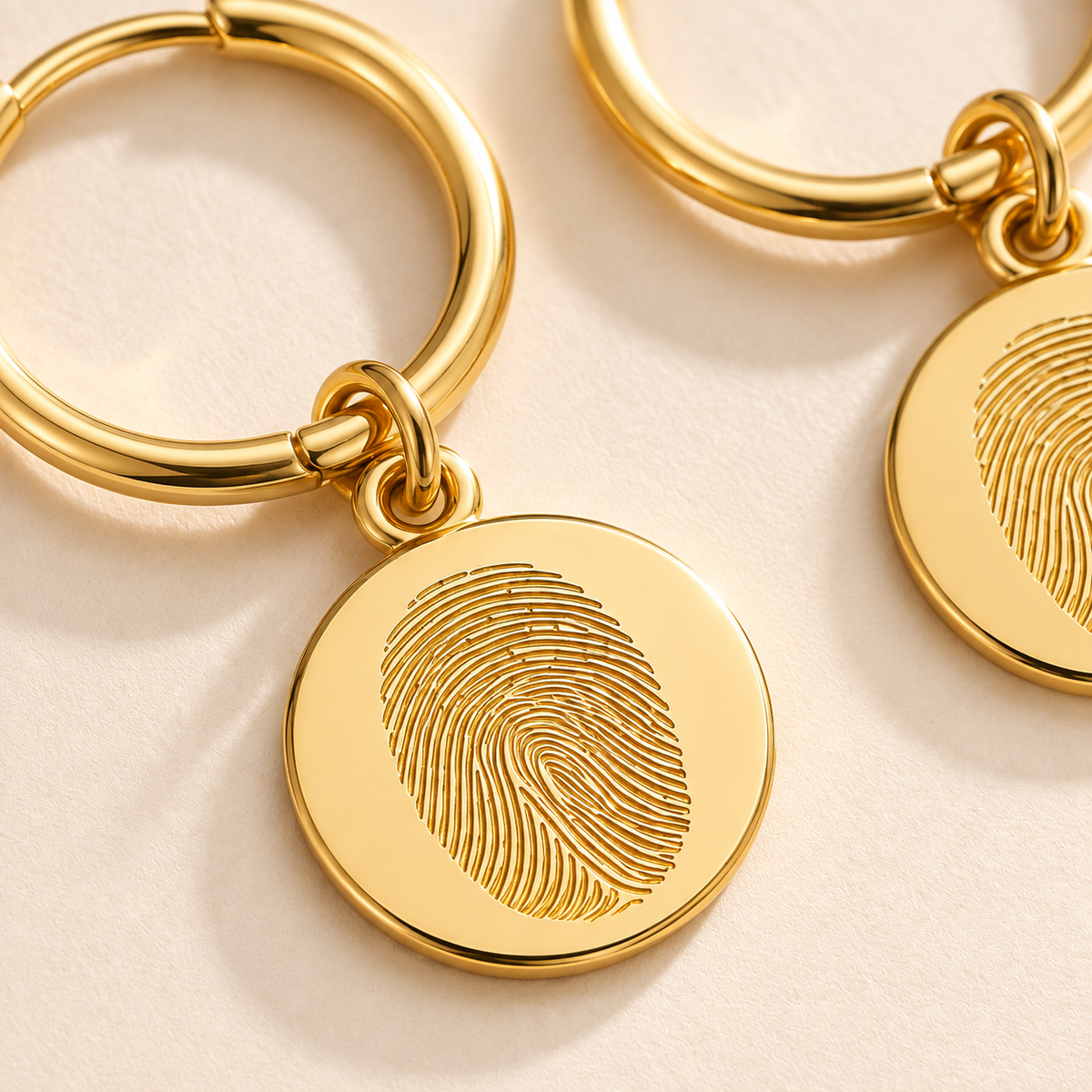 Custom Fingerprint Huggie Hoop Earrings detail photo - closeup of engraved gold fingerprint discs Anthology Jewelry