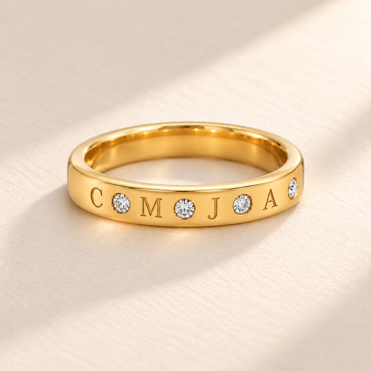 Gold flush stone initial band with four engraved initials C M J A