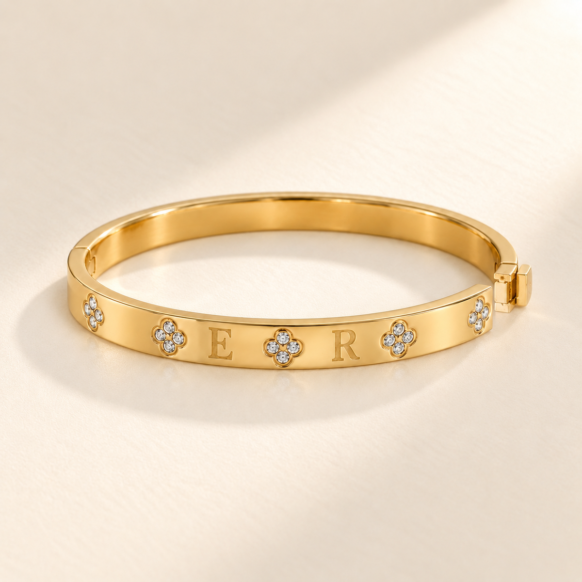 Custom Four-Stone Initial Bangle open clasp detail photo - rigid hinged bangle with E and R initials and fixed clear-stone motifs Anthology Jewelry