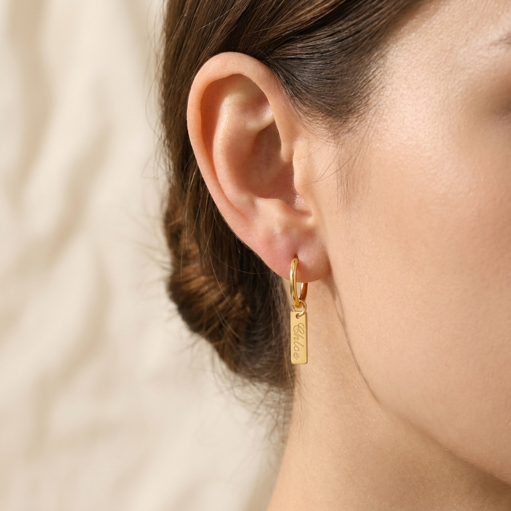 Custom Nameplate Huggie Hoop Earrings lifestyle photo - woman wearing gold huggie hoop earring with engraved charm Anthology Jewelry