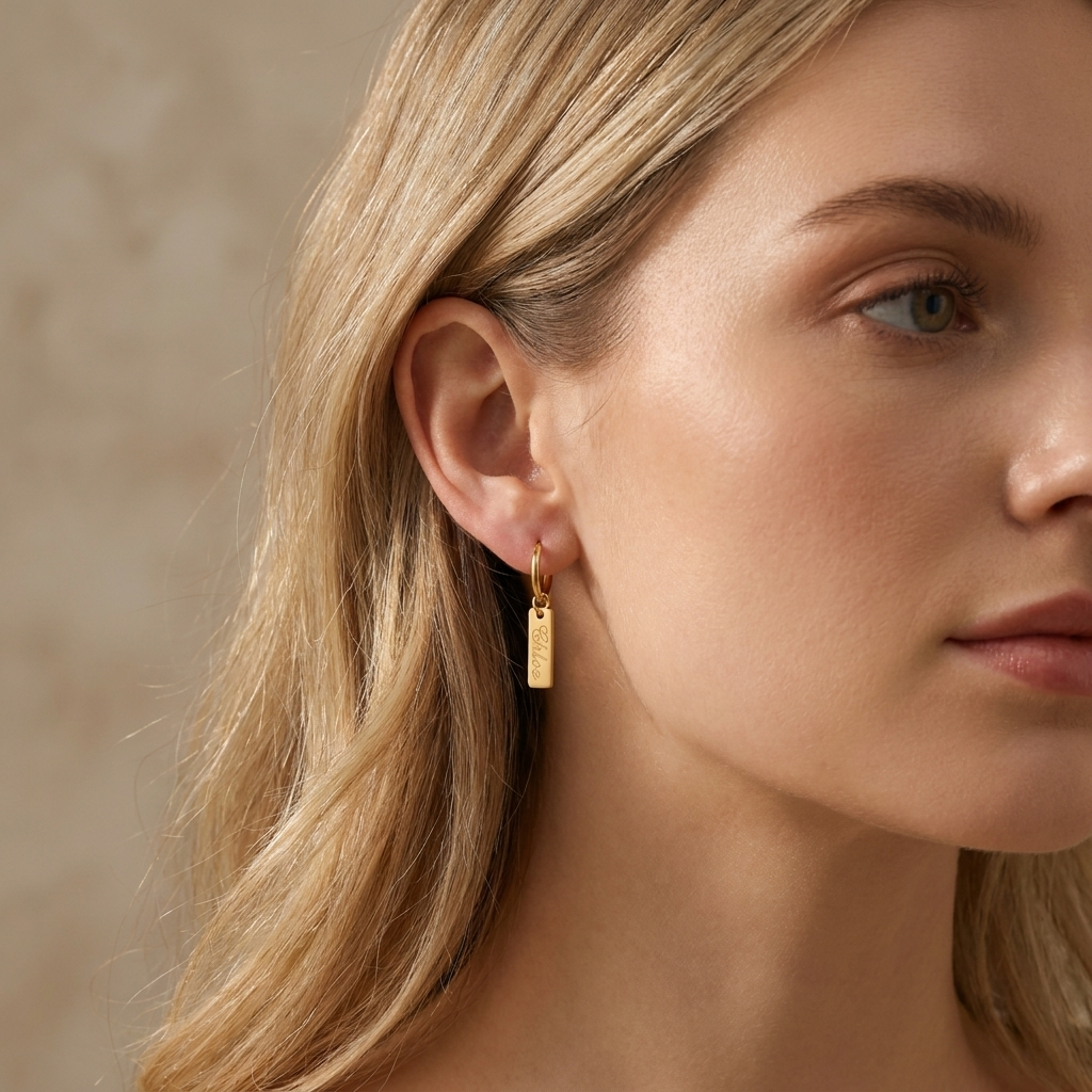 Custom Nameplate Huggie Hoop Earrings lifestyle photo - woman wearing gold huggie hoop earring three quarter angle Anthology Jewelry