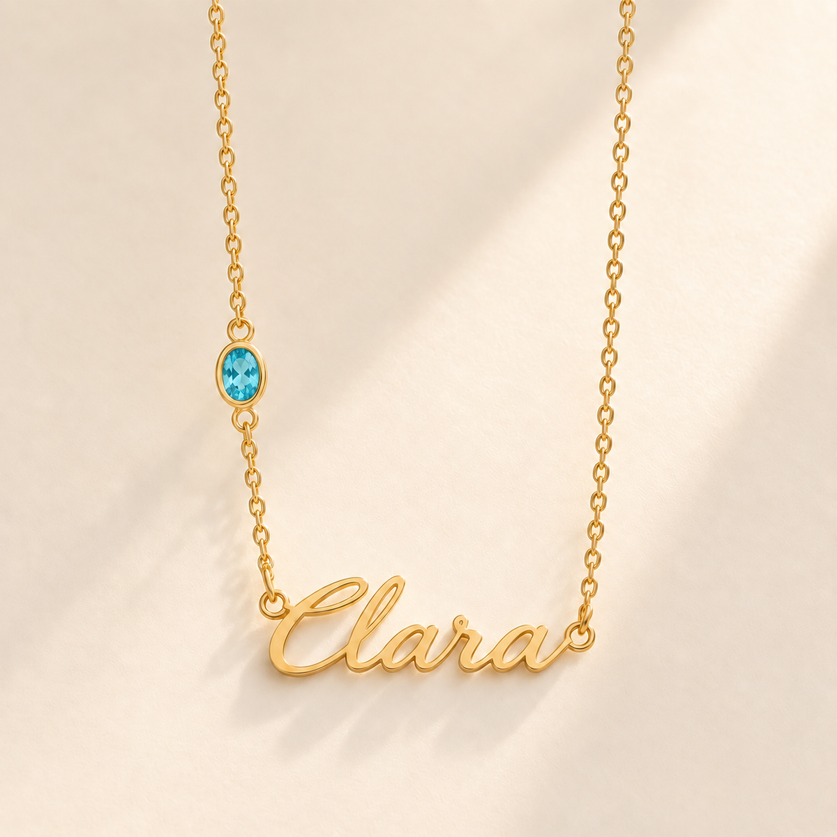 Gold script Clara necklace with december birthstone-color stone on left chain