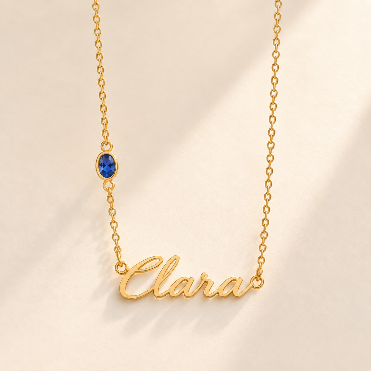 Gold script Clara necklace with september birthstone-color stone on left chain