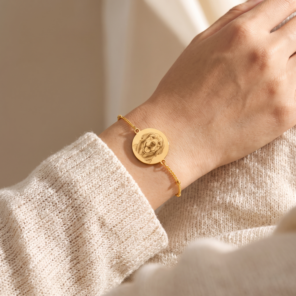 Custom Pet Portrait Bracelet lifestyle photo - gold dog portrait bracelet worn on wrist with cream knit sweater Anthology Jewelry