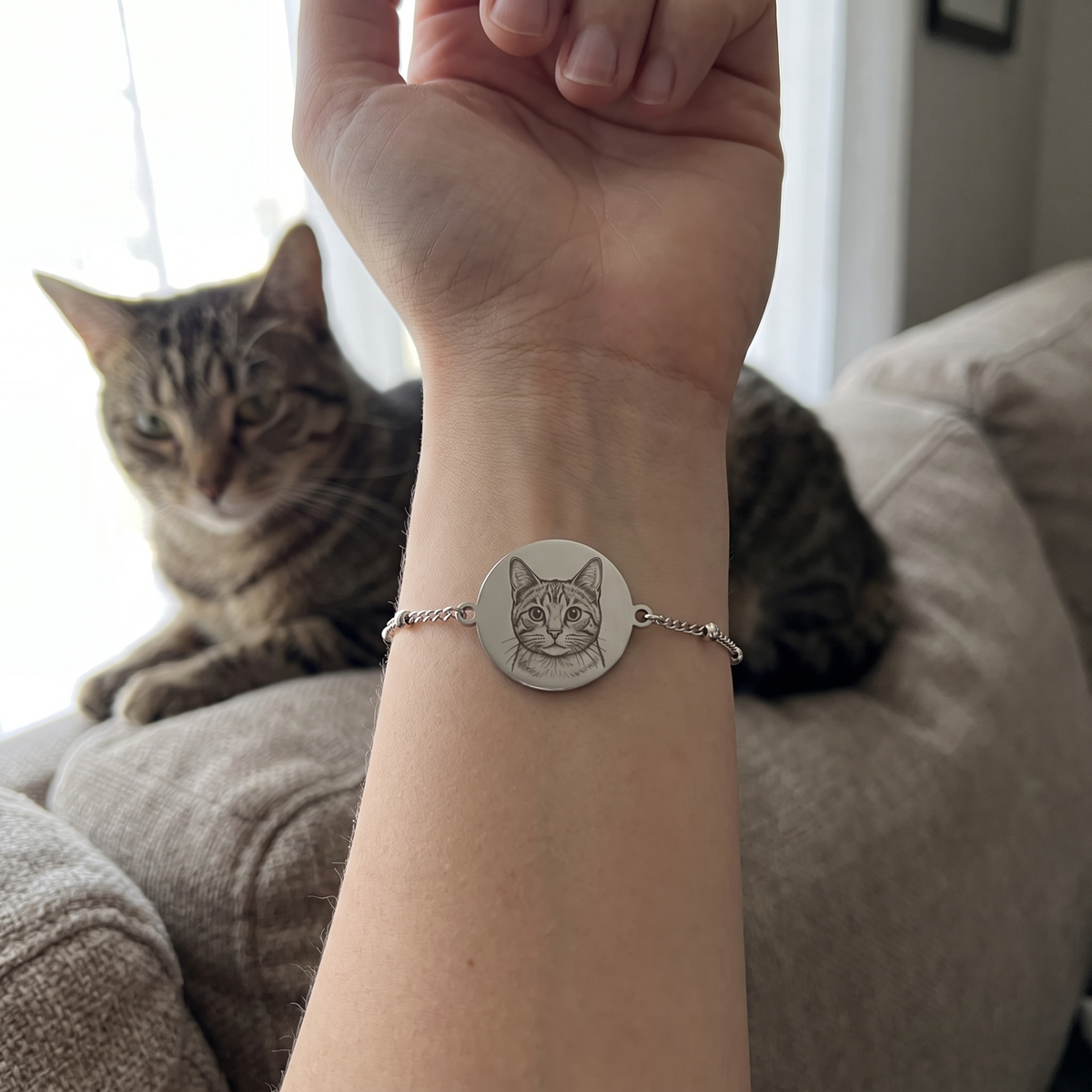Custom Pet Portrait Bracelet UGC photo - silver cat portrait bracelet worn with a tabby cat in the background Anthology Jewelry