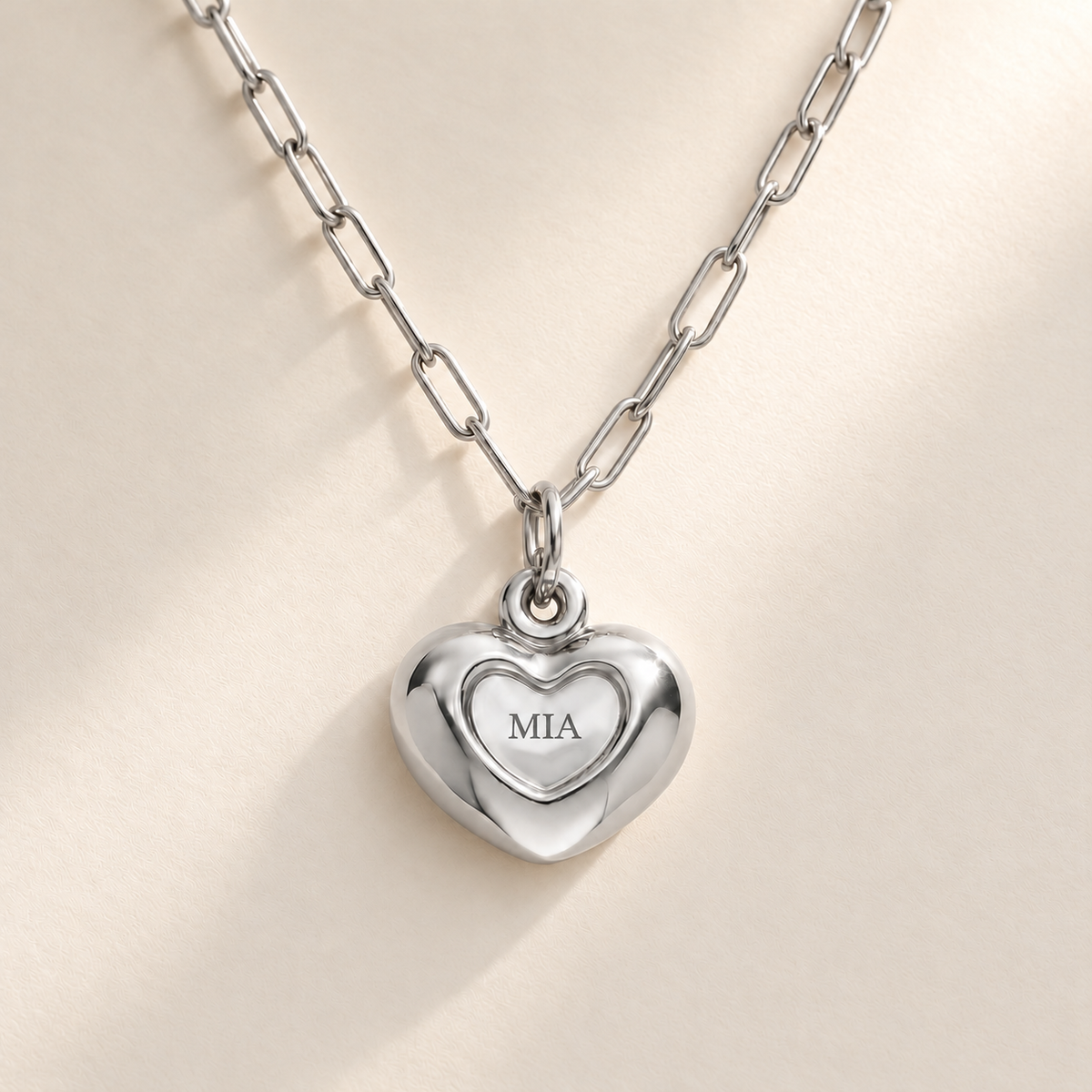 Custom Puffy Heart Necklace hero photo - silver heart with MIA engraving and soft consistent diagonal light Anthology Jewelry