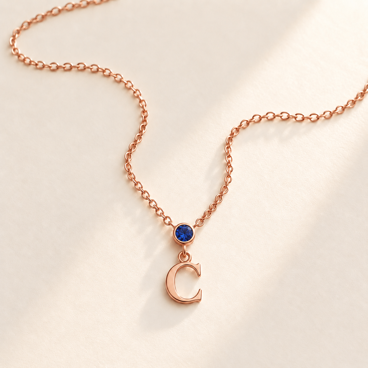Rose gold vertical birthstone initial necklace with blue stone