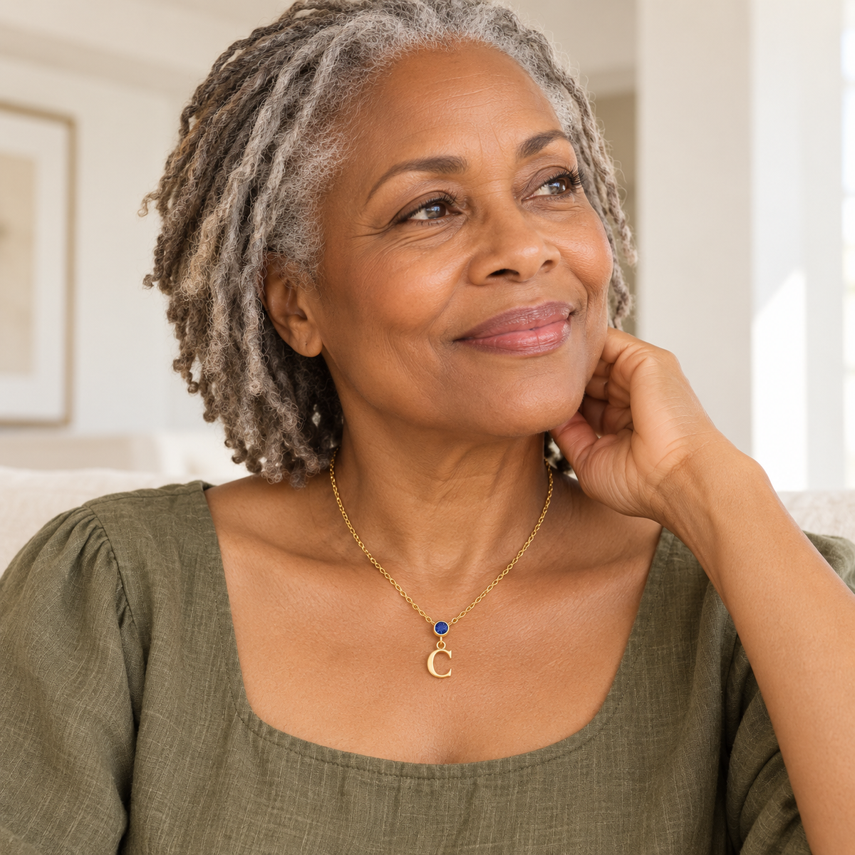 Older woman wearing vertical birthstone initial necklace