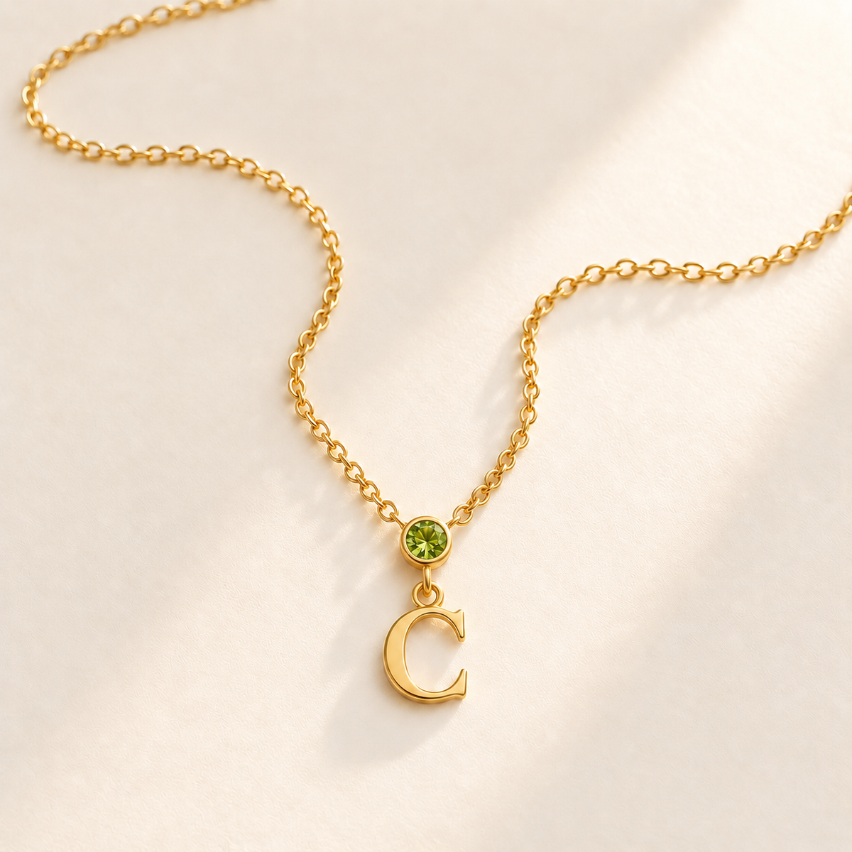 Gold vertical initial necklace with august birthstone-color center stone