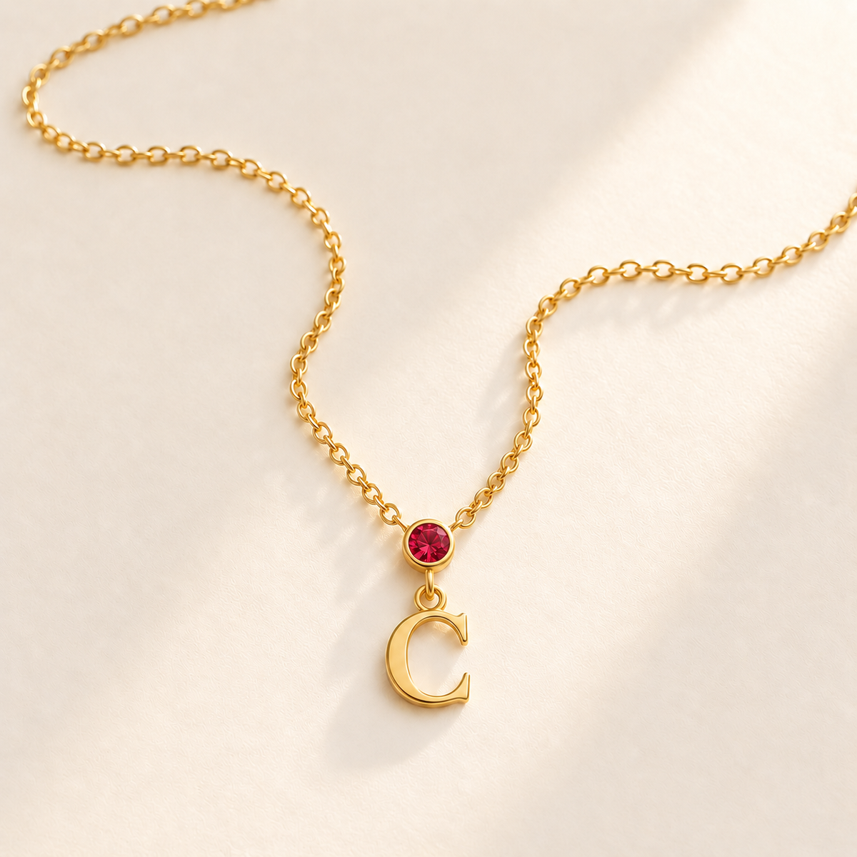Gold vertical initial necklace with july birthstone-color center stone