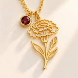 Custom Birth Flower & Birthstone Necklace detail photo - macro of gold January carnation birth flower cutout with stem and leaves beside a round garnet birthstone drop Anthology Jewelry