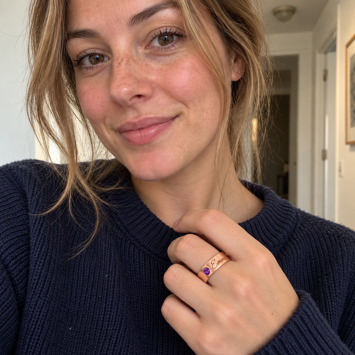 Custom Wide Band Name Ring with Birthstone UGC-style photo - rose gold amethyst ring with Emma engraving in a candid-style indoor selfie Anthology Jewelry