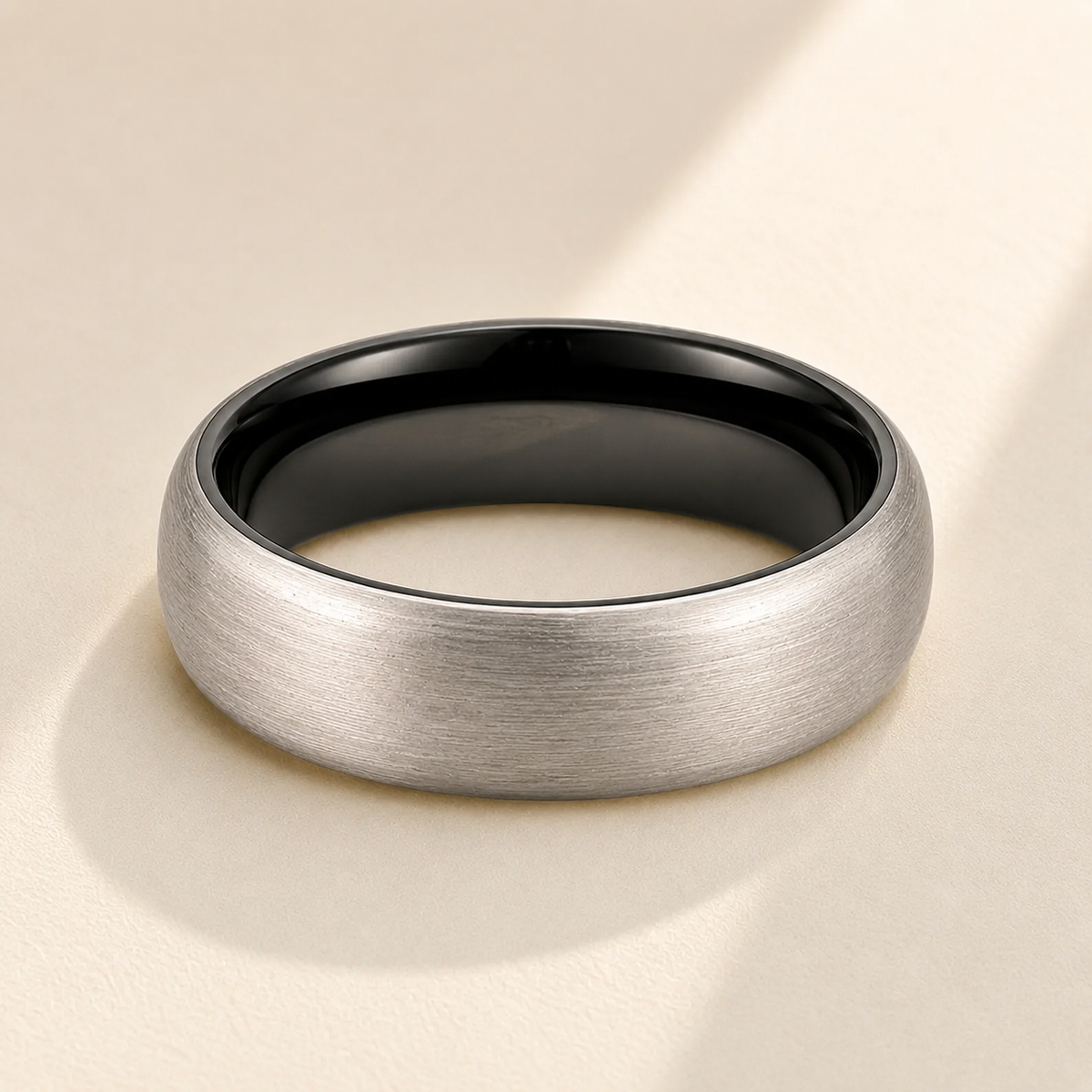 Classic Brushed Tungsten Wedding Band hero photo - two-toned tungsten ring with black interior on display Anthology Jewelry