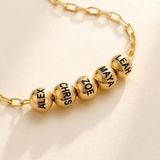 Custom Add-A-Bead Necklace detail photo - close view of engraved gold name beads Anthology Jewelry