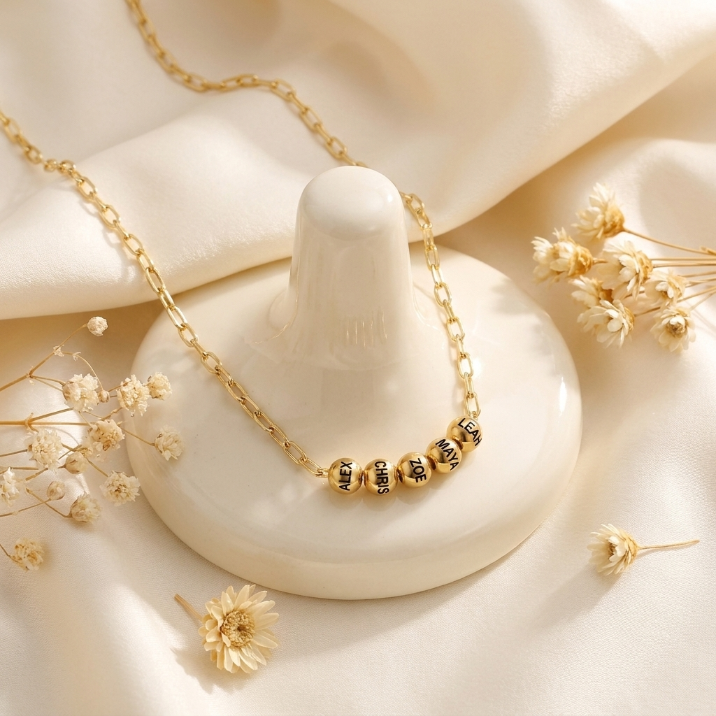 Custom Add-A-Bead Necklace glamour photo - gold name bead necklace styled on cream surface Anthology Jewelry