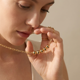 Custom Add-A-Bead Necklace lifestyle photo - woman holding gold name bead necklace in hand Anthology Jewelry