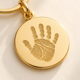 Custom Baby Handprint or Footprint Keychain detail photo - close-up of engraved gold baby handprint tag Anthology Jewelry
