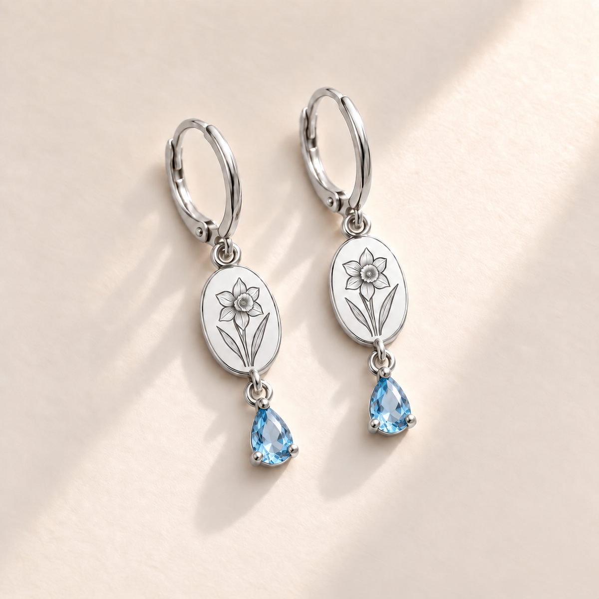 Custom Birth Flower & Birthstone Drop Earrings December silver hero photo - narcissus engraving and faceted blue topaz pear stones Anthology Jewelry