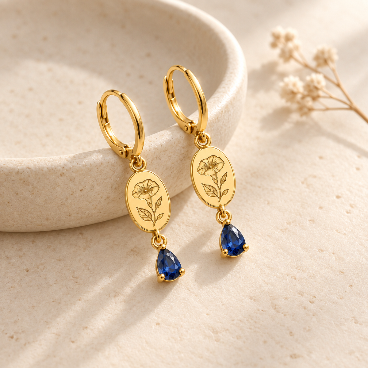 Custom Birth Flower & Birthstone Drop Earrings glamour photo - gold floral earrings styled on ivory dish Anthology Jewelry