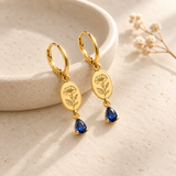 Custom Birth Flower & Birthstone Drop Earrings glamour photo - gold floral earrings styled on ivory dish Anthology Jewelry