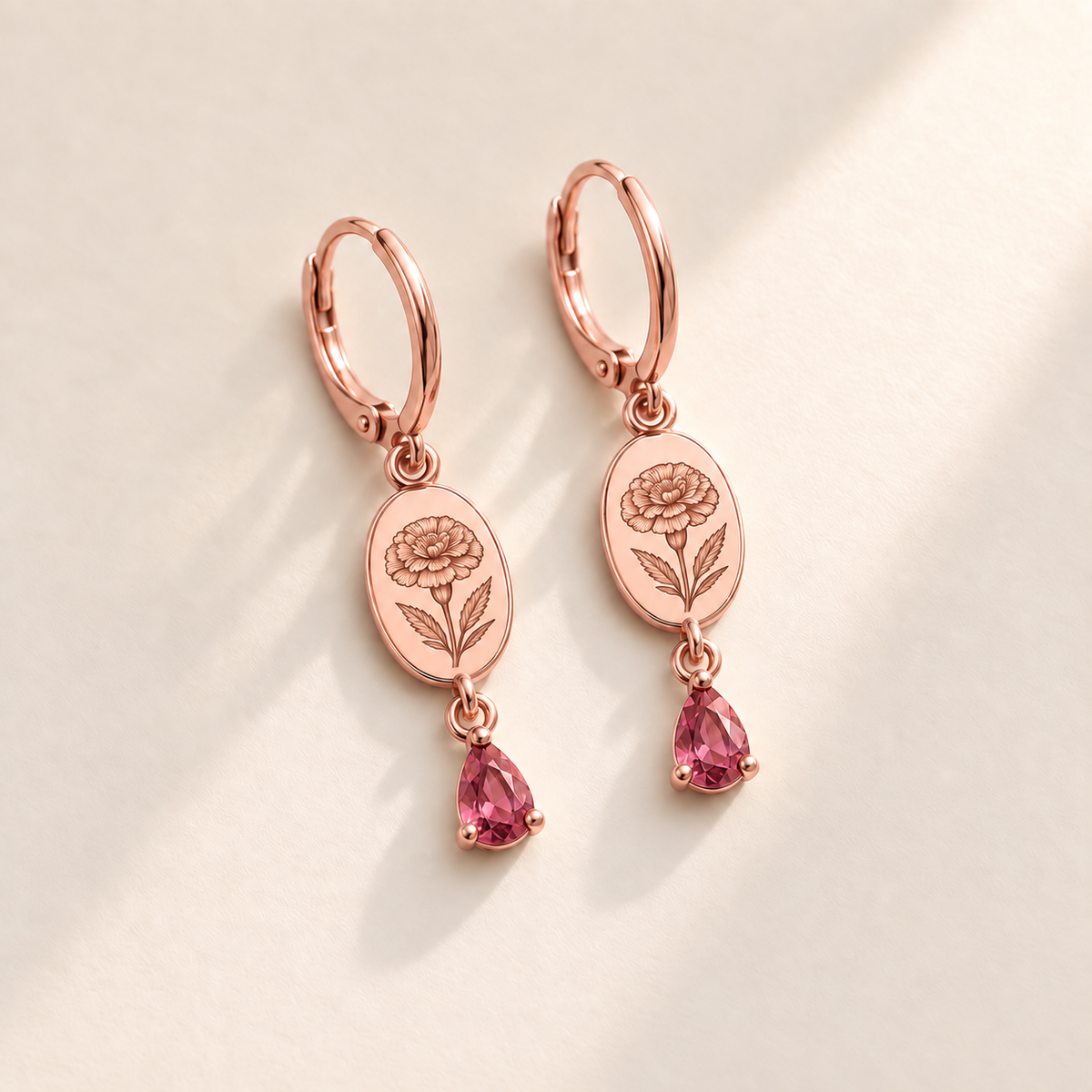 Custom Birth Flower & Birthstone Drop Earrings october rose gold hero photo - engraved round marigold flower with dense layered petals and serrated leaves with pink tourmaline pear stones Anthology Jewelry