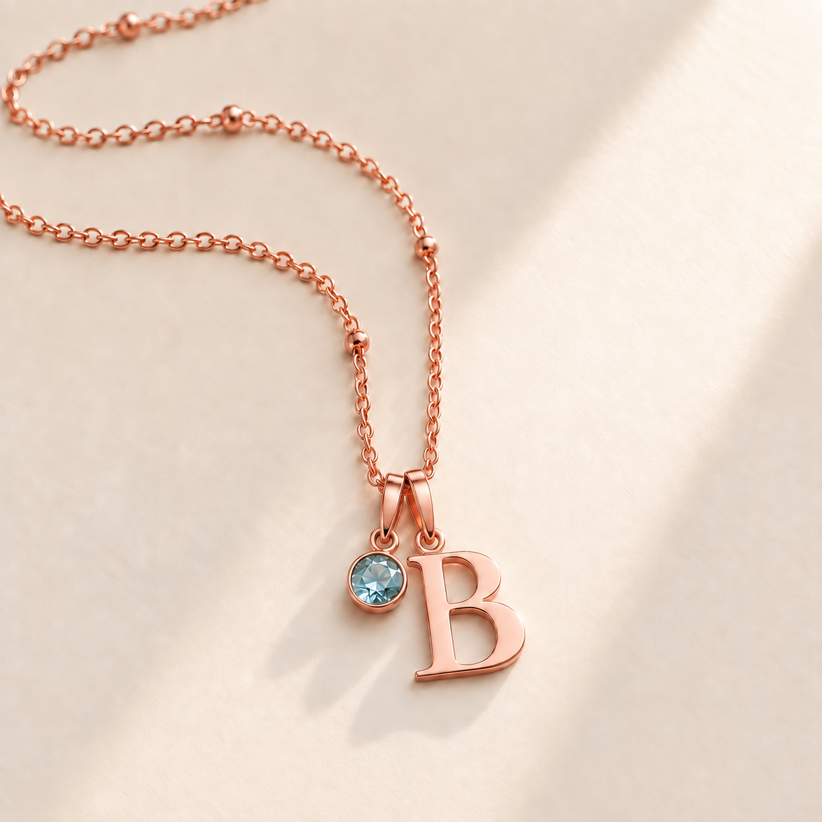 Custom Birthstone Initial Necklace rose gold March birthstone photo - serif initial B with round pale blue stone Anthology Jewelry