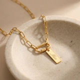 Custom Carabiner Charm Necklace glamour photo - gold carabiner charm necklace styled on ceramic dish Anthology Jewelry