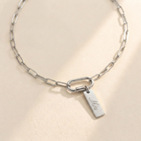 Custom Carabiner Charm Necklace hero photo - silver paperclip chain necklace with carabiner clasp and engraved charm on cream background Anthology Jewelry