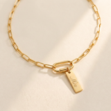 Custom Carabiner Charm Necklace hero photo - gold paperclip chain necklace with carabiner clasp and engraved charm on cream background Anthology Jewelry