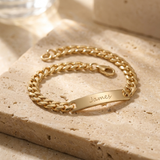Custom Curb Chain ID Bracelet glamour photo - gold curb chain ID bracelet on travertine stone Anthology Jewelry