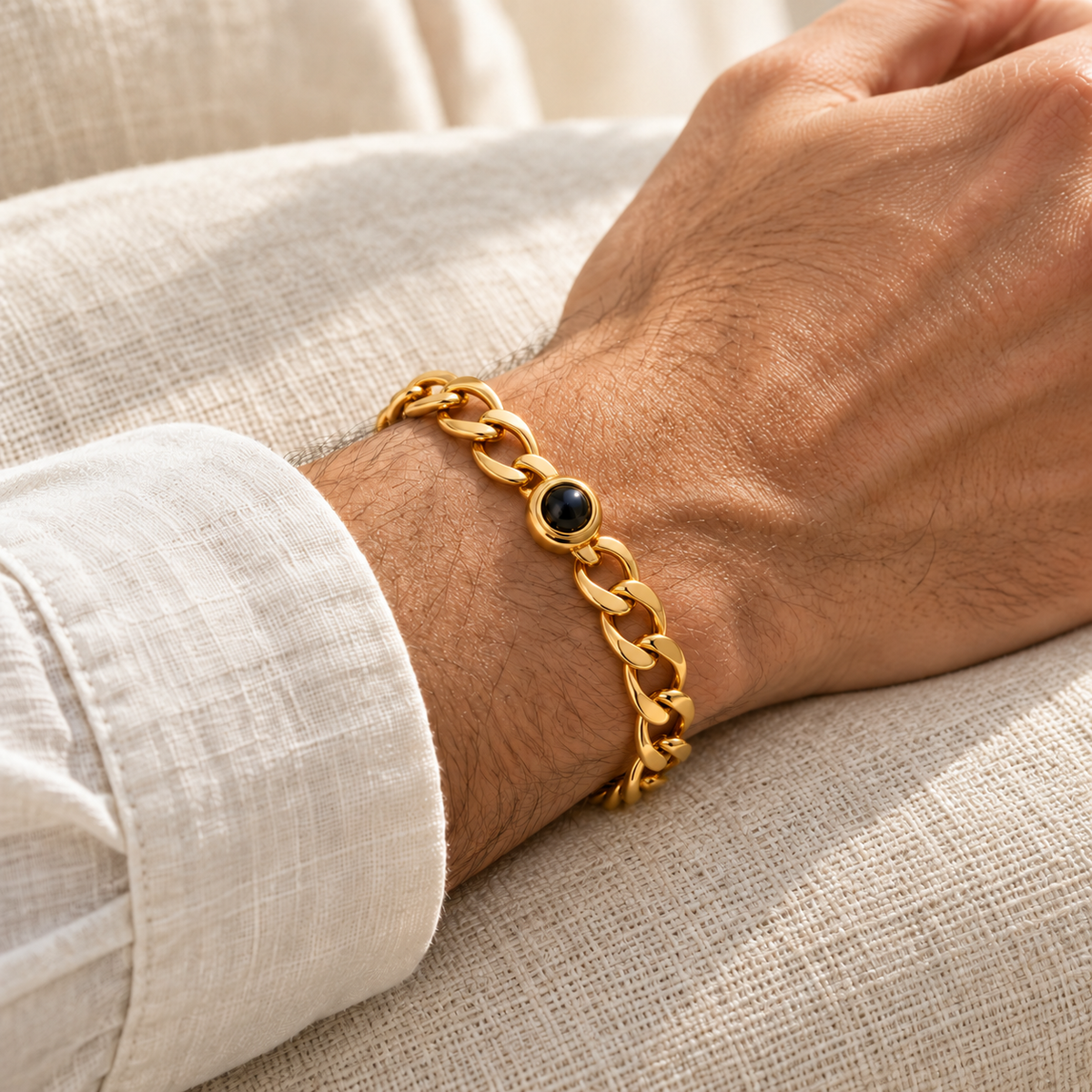 Custom Curb Link Photo Bracelet lifestyle photo - Gold photo bracelet worn with a cream linen cuff, with open oval curb links and dark projection lens - Anthology Jewelry