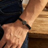 Custom Fingerprint Bracelet Men's Braided Cord lifestyle photo - worn on wrist resting on table Anthology Jewelry