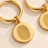 Custom Fingerprint Huggie Hoop Earrings detail photo - closeup of engraved gold fingerprint discs Anthology Jewelry