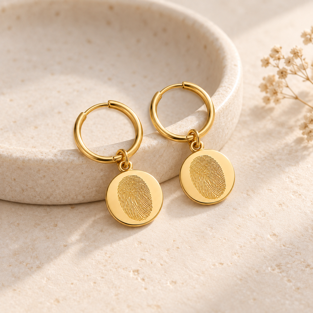 Custom Fingerprint Huggie Hoop Earrings glamour photo - gold earrings styled on ivory ceramic dish Anthology Jewelry