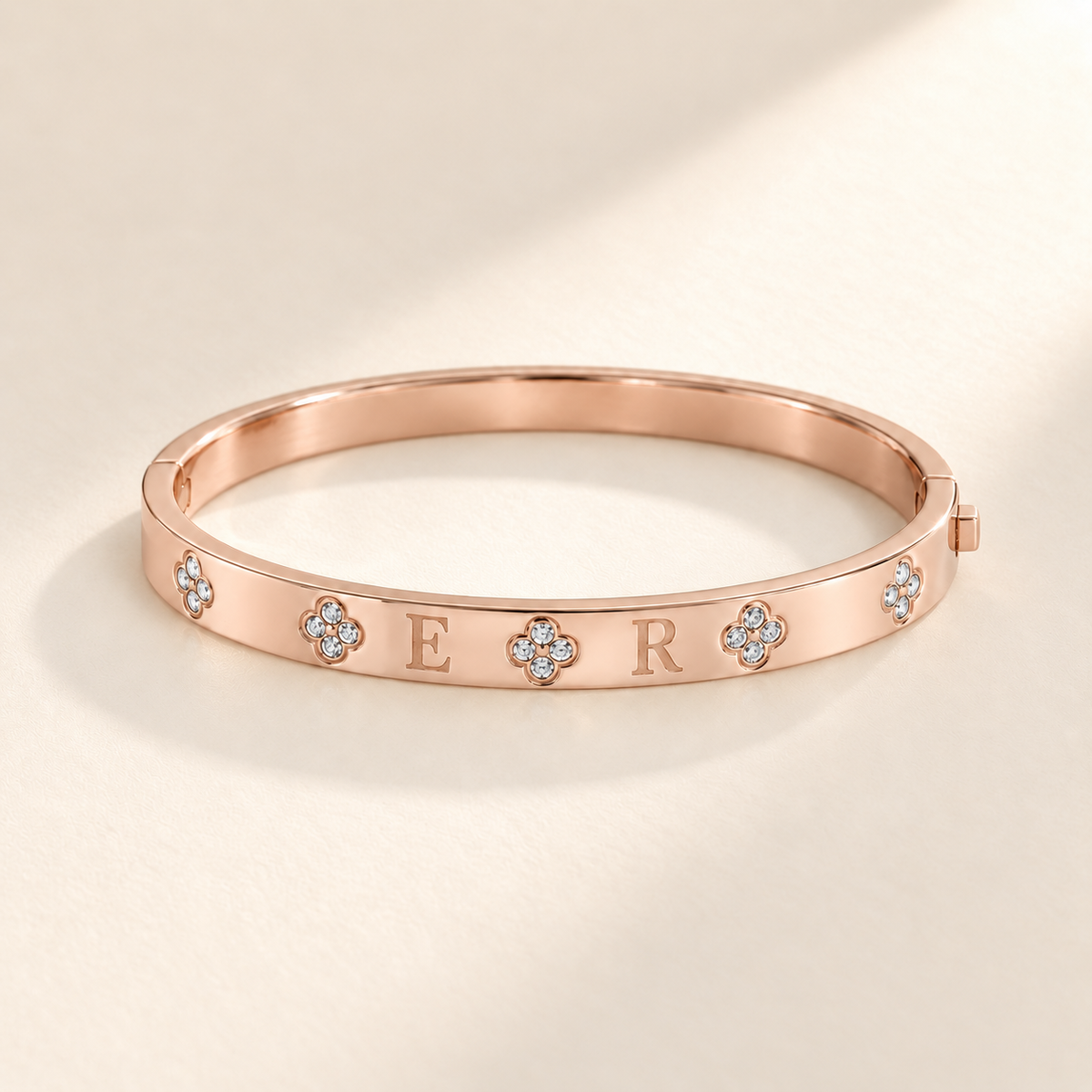 Custom Four-Stone Initial Bangle rose gold hero photo - rigid hinged bangle with E and R initials and fixed clear-stone motifs Anthology Jewelry
