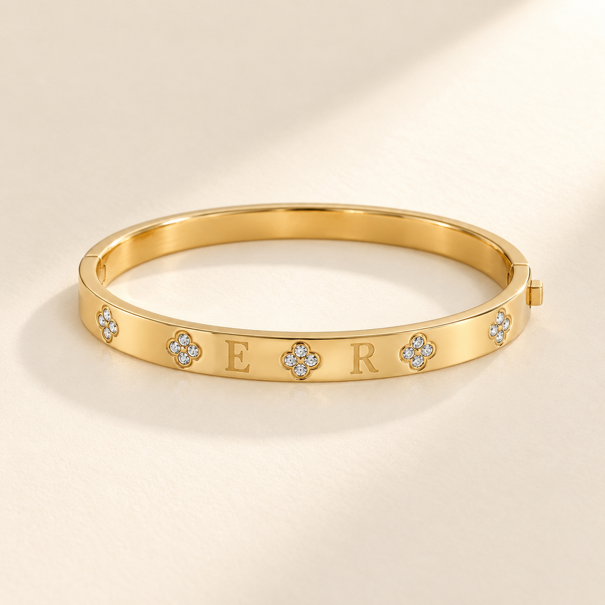 Custom Four-Stone Initial Bangle gold hero photo - rigid hinged bangle with E and R initials and fixed clear-stone motifs Anthology Jewelry