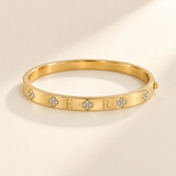 Custom Four-Stone Initial Bangle gold hero photo - rigid hinged bangle with E and R initials and fixed clear-stone motifs Anthology Jewelry