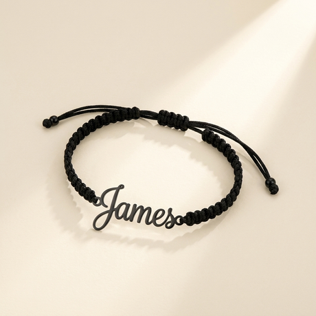 Custom Handwriting Bracelet Men's Braided Cord black hero photo - open cursive cut-out name charm on black woven cord Anthology Jewelry