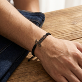 Custom Handwriting Bracelet Men's Braided Cord lifestyle photo - worn on wrist resting on table Anthology Jewelry