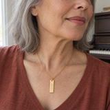 Custom Handwriting ID Necklace professional close model photo - gold ID pendant worn on an older woman Anthology Jewelry