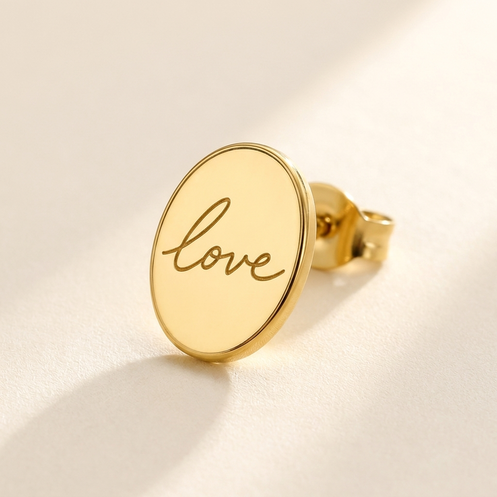 Custom Handwriting Oval Stud Earrings detail photo - close-up of gold oval stud engraved with handwritten love Anthology Jewelry